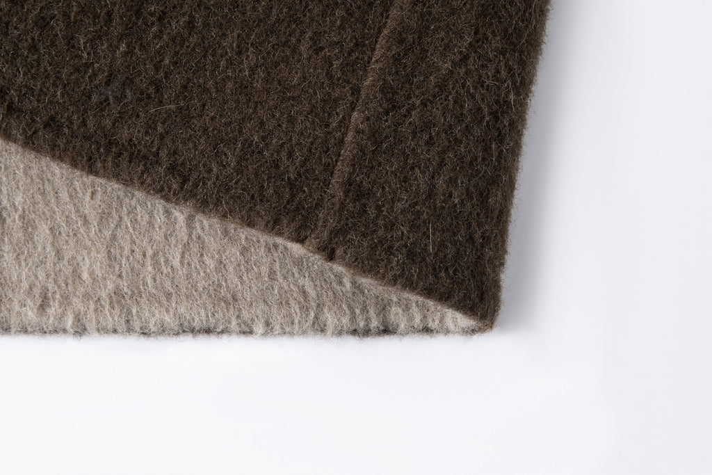 Close-up of the coat's hem edge and contrasting lighter inner face.