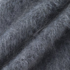 Close-up of the Grey hooded scarf's fuzzy knitted texture and fine fibres.