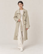 AI-assisted casual styling of THE LANE 9855 Coffee Green trench coat, with ivory straight-leg trousers and minimal low-top trainers.