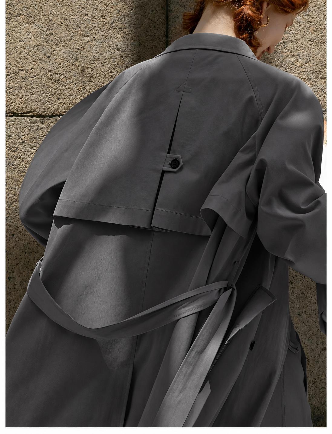 Close-up of the Dark Grey coat's layered back panel, centre button tab and waist belt.
