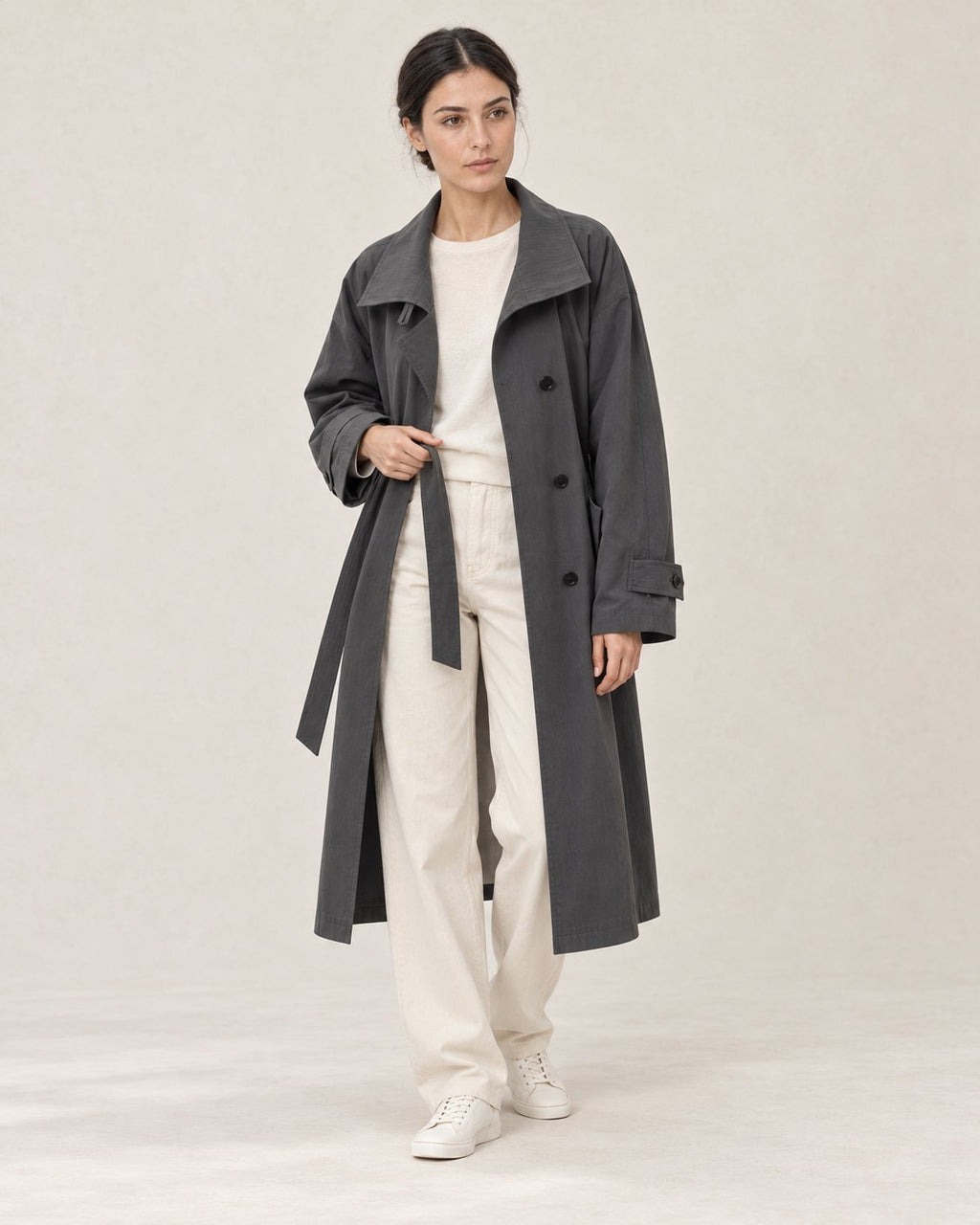 AI-assisted casual styling of THE LANE 9855 Dark Grey trench coat, with ivory straight-leg trousers and minimal low-top trainers.