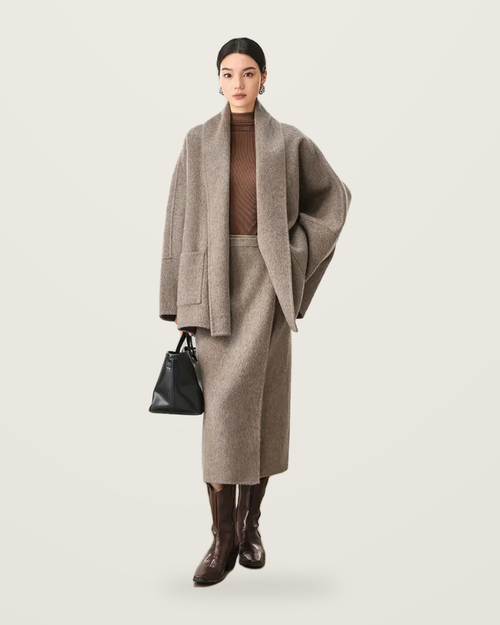 Oatmeal grey wrap jacket and skirt set, worn with a brown roll-neck and tall boots.