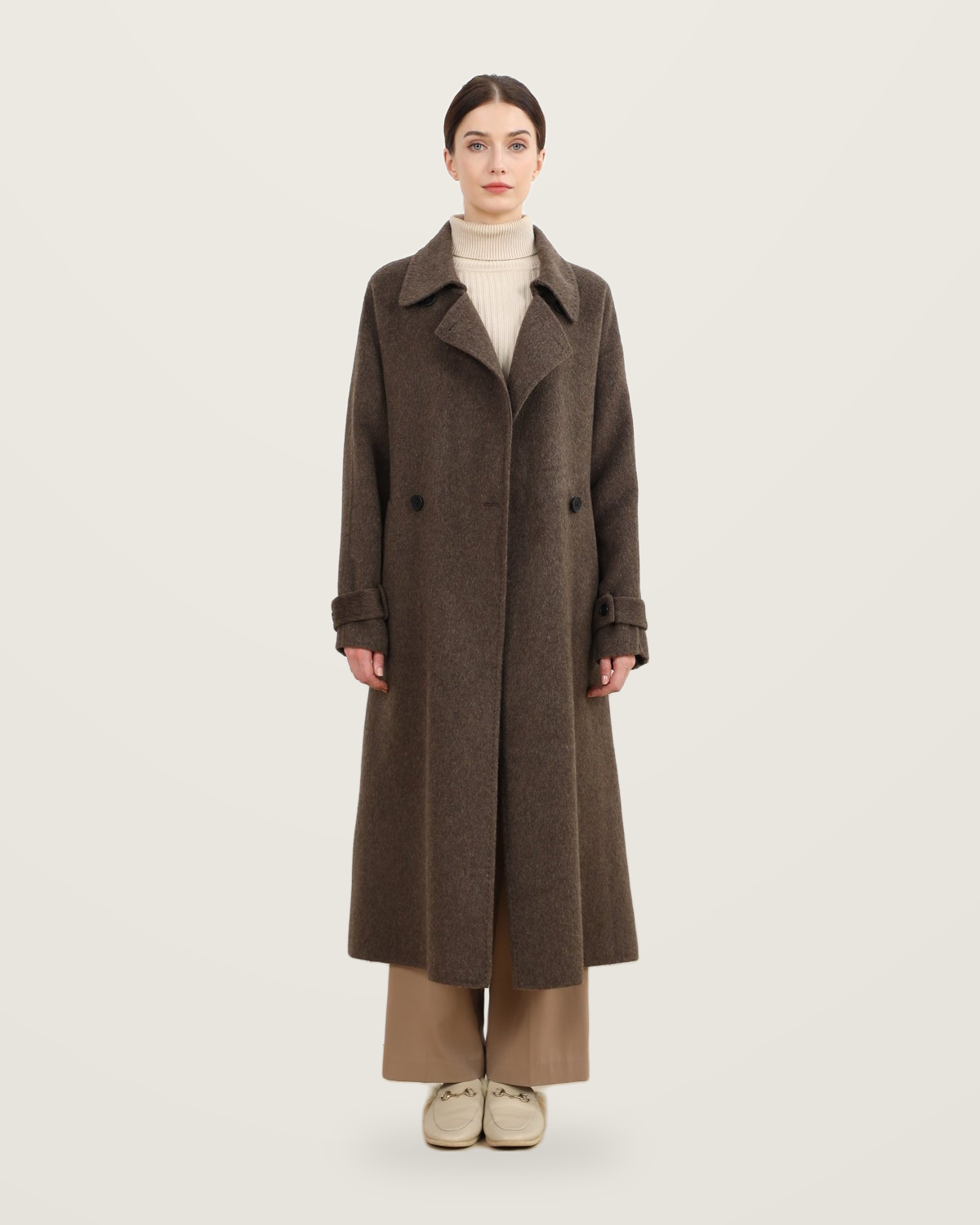 Coffee-coloured coat with cuff tabs, worn with a cream roll-neck and taupe trousers.