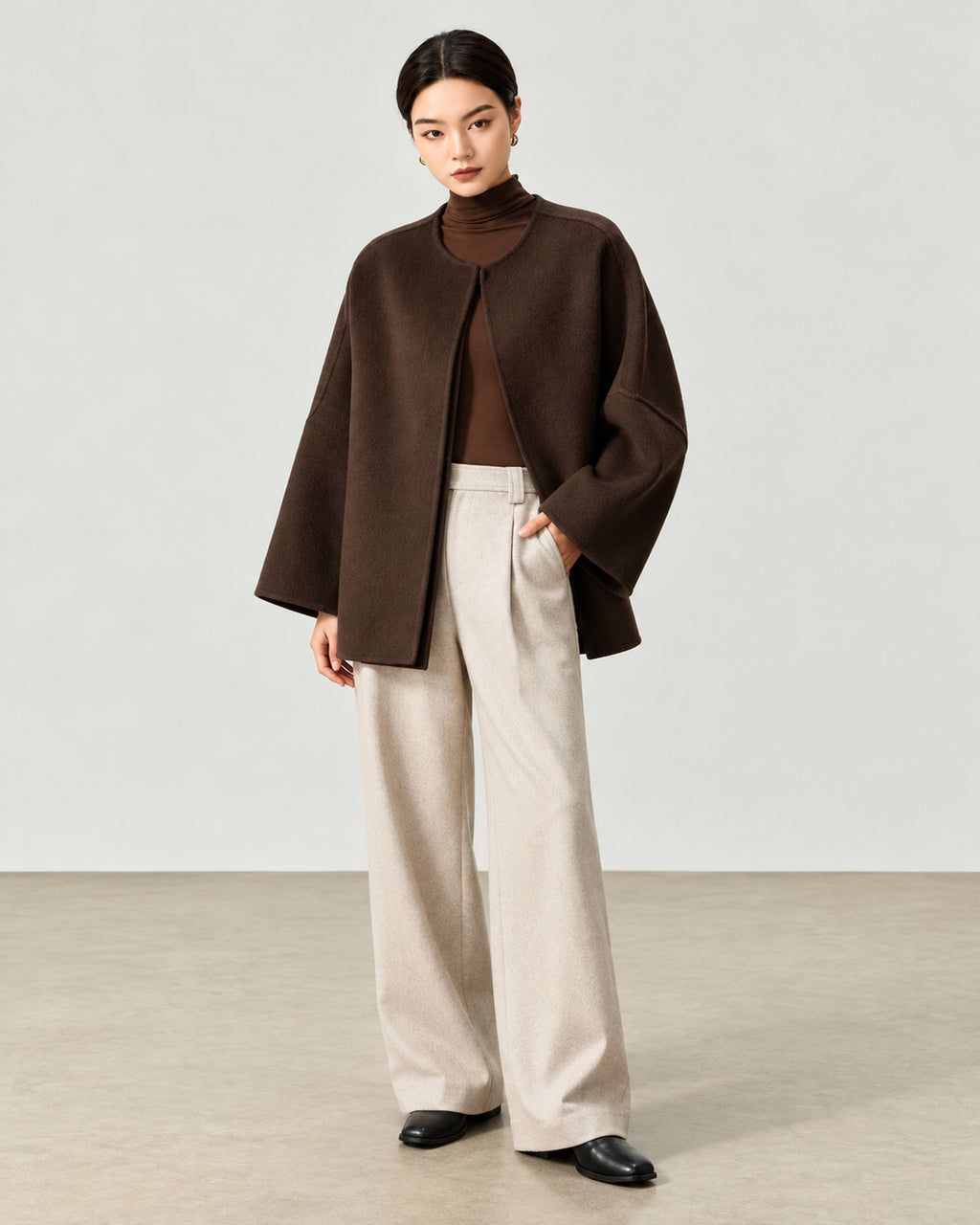 AI-assisted styling of THE LANE 007 Coffee pure wool oversized short coat, round neckline, dropped shoulders, wide sleeves and no patch pockets. Full-length styling view.