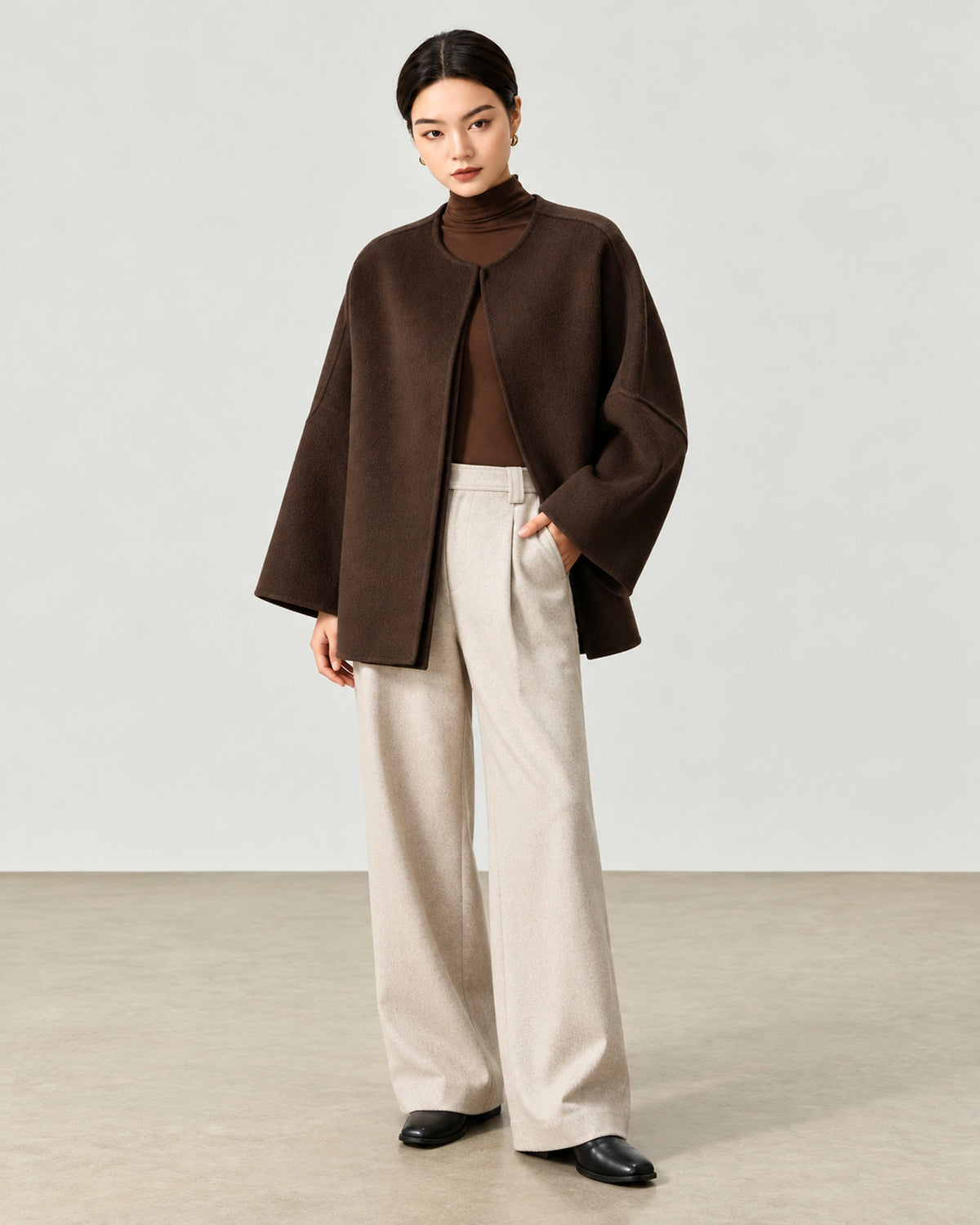 AI-assisted styling of THE LANE 007 Coffee pure wool oversized short coat, round neckline, dropped shoulders, wide sleeves and no patch pockets. Full-length styling view.