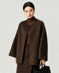 AI-assisted styling of THE LANE 007 Coffee pure wool oversized short coat, round neckline, dropped shoulders, wide sleeves and no patch pockets. Front styling view.