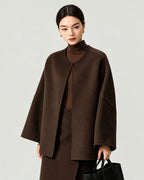 AI-assisted styling of THE LANE 007 Coffee pure wool oversized short coat, round neckline, dropped shoulders, wide sleeves and no patch pockets. Front styling view.