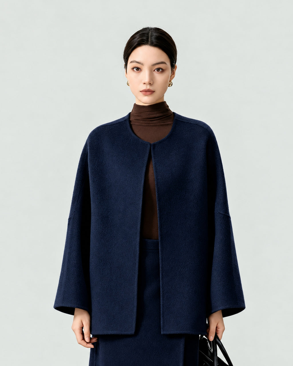 AI-assisted styling of THE LANE 007 Navy pure wool oversized short coat, round neckline, dropped shoulders and wide sleeves. Front styling view.
