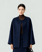 AI-assisted styling of THE LANE 007 Navy pure wool oversized short coat, round neckline, dropped shoulders and wide sleeves. Front styling view.
