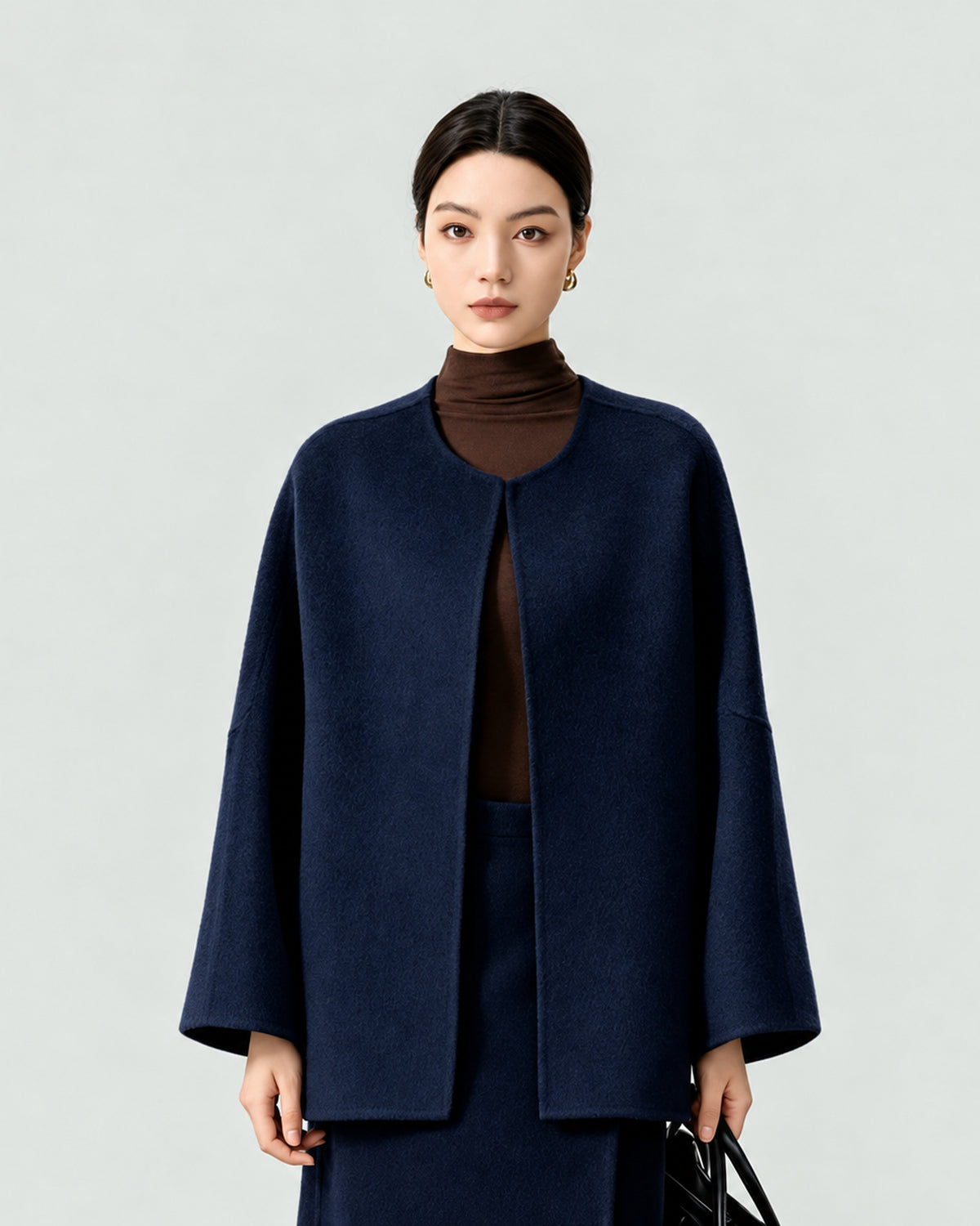 AI-assisted styling of THE LANE 007 Navy pure wool oversized short coat, round neckline, dropped shoulders and wide sleeves. Front styling view.