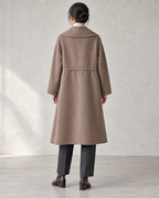 Vienna coat in Brown, relaxed rear model view with centre back seam and integral drawcord channel — AI-assisted styling image.