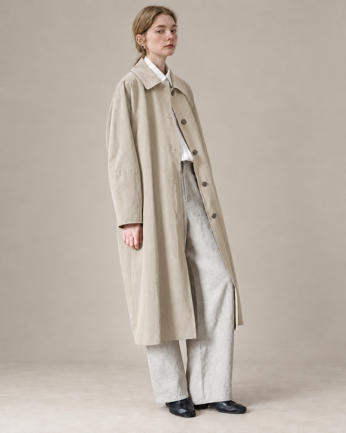 Cream Richmond cotton-Tencel trench coat, AI-assisted adaptation of the original model photograph to a warm neutral studio.
