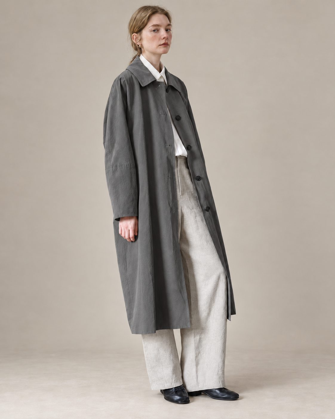 Dark Grey Richmond cotton-Tencel trench coat, AI-assisted adaptation of the original model photograph to a warm neutral studio.