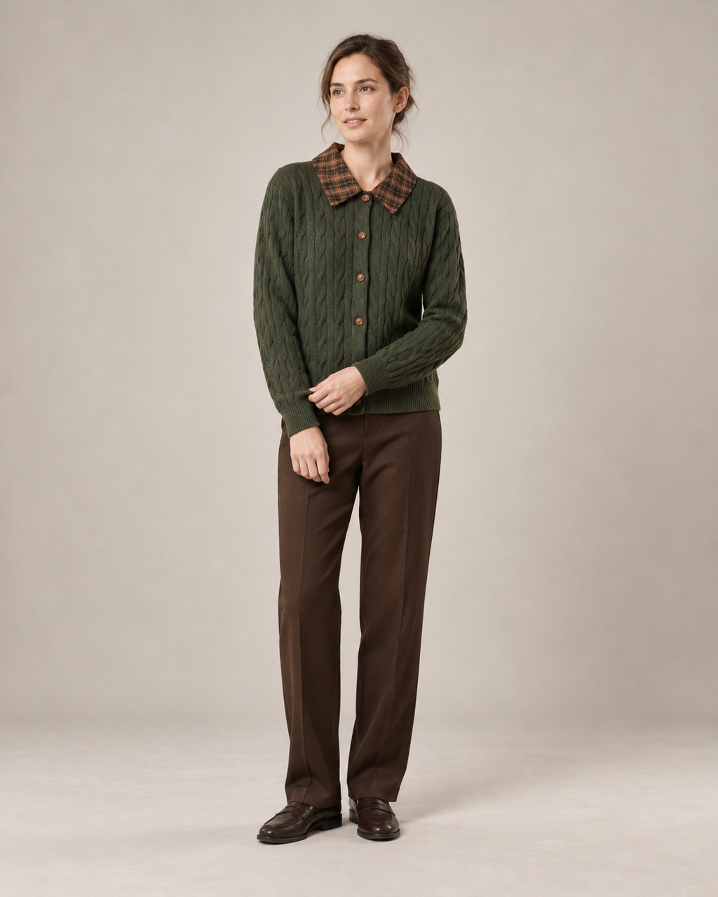 Olive cable-knit cardigan with a brown check collar, worn with straight brown trousers and leather loafers. AI-assisted styling based on the supplied garment photograph.