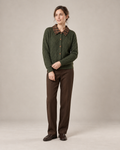 Olive cable-knit cardigan with a brown check collar, worn with straight brown trousers and leather loafers. AI-assisted styling based on the supplied garment photograph.