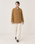 AI-assisted styling of THE LANE 25219 Brown straight-cut coat, walking front view with all eight buttons fastened; cream trousers and chocolate-brown ankle boots.